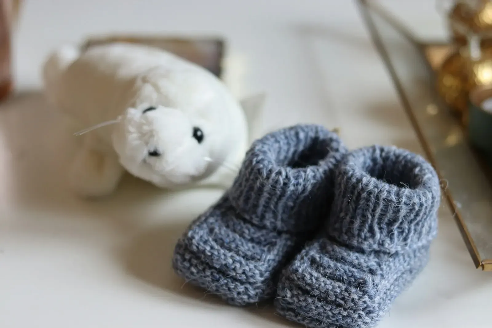 Gri örgü bebek patikleri ve peluş oyuncak