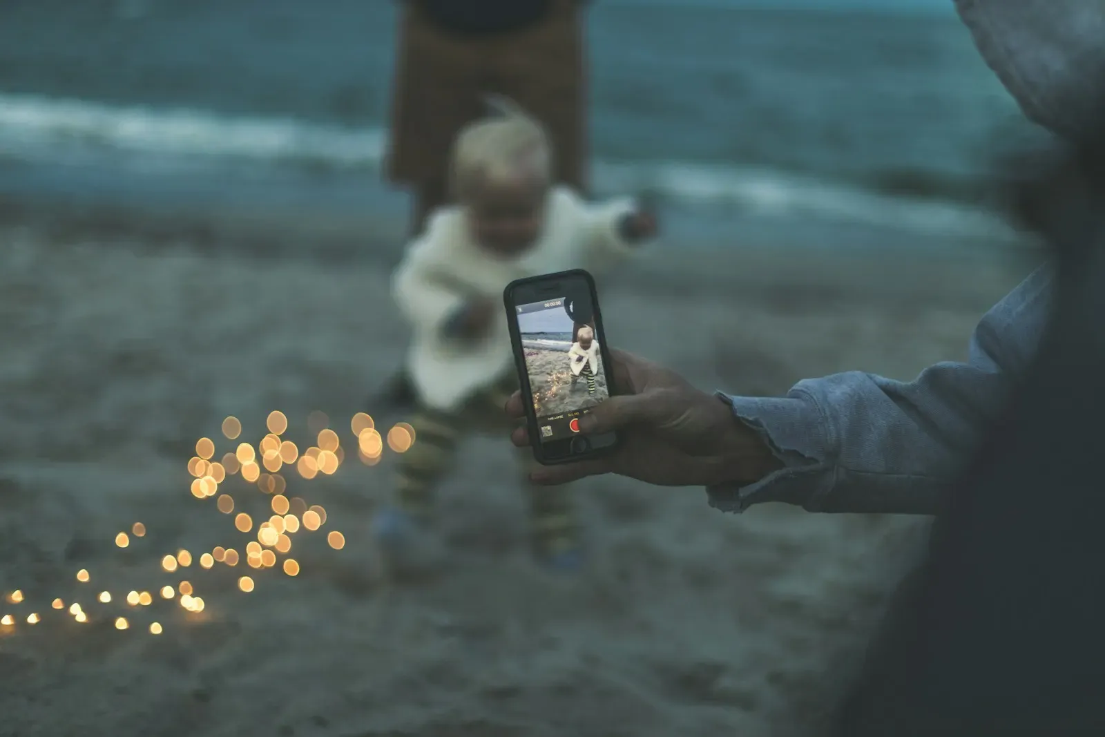 Telefonla bebeğin fotoğrafını çeken el